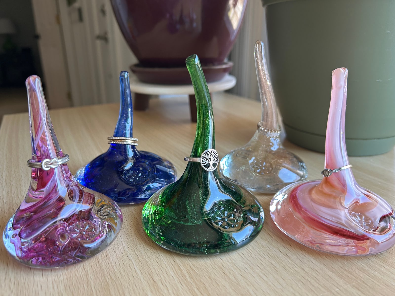 Five colourful glass ring holders with slender curved stems