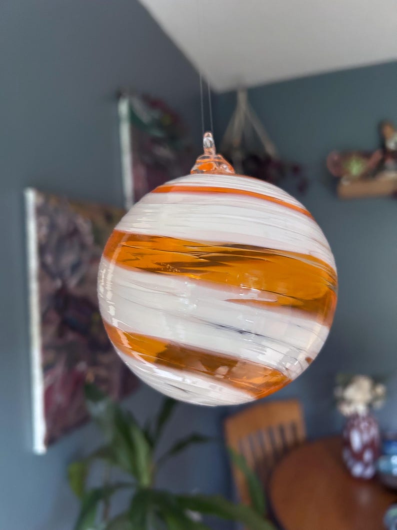 An amber-orange and white glass ornament